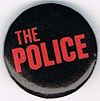 The Police small round button diff logo light red on black.jpg